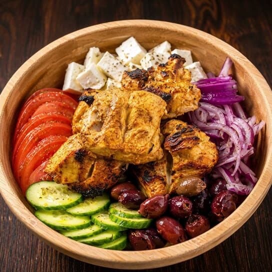 Greek chicken bowl with feta, olives, cucumber, and tomato at Mediterra Houston