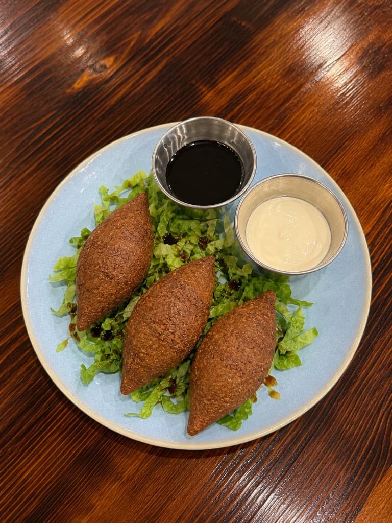 Fried kibbeh with pomegranate molasses and garlic sauce at Mediterra Houston